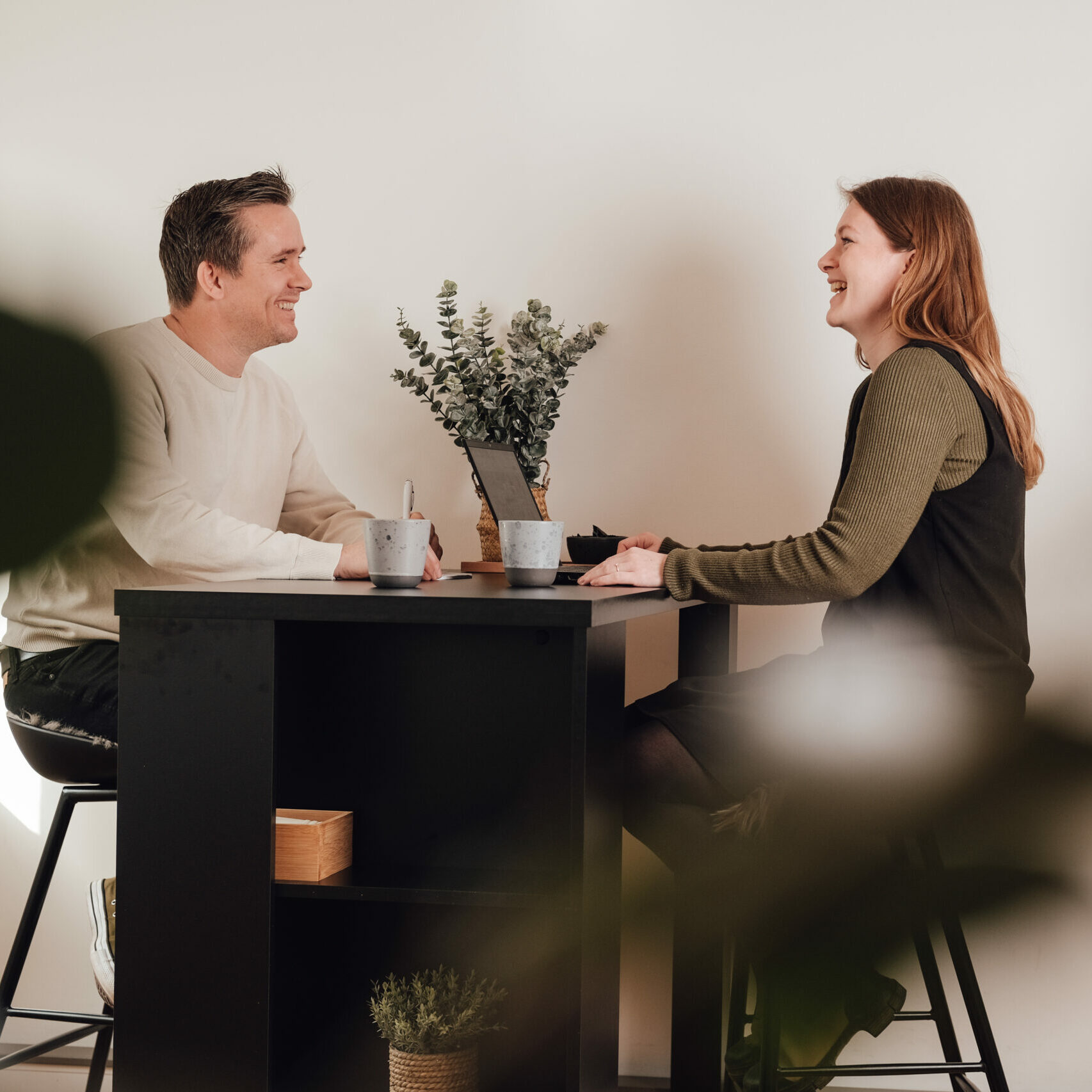 To kolleger i samtale over en kop kaffe på kontoret